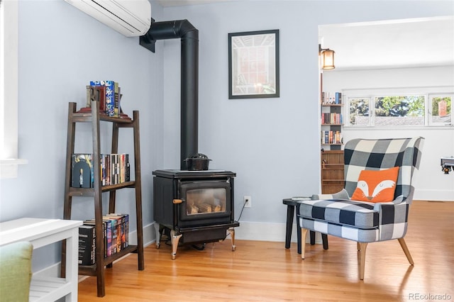 4321 Winona Ct, Denver, CO 80212 - sitting room with a wood stove, a wall unit AC, wood finished floors, and baseboards