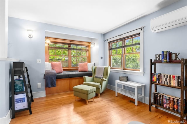 4321 Winona Ct, Denver, CO 80212 - living area featuring a wall mounted air conditioner, wood finished floors, and baseboards
