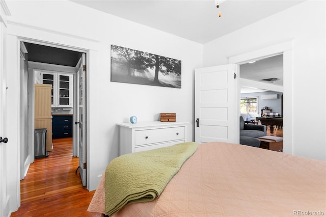 4321 Winona Ct, Denver, CO 80212 - bedroom featuring wood finished floors and a wall unit AC