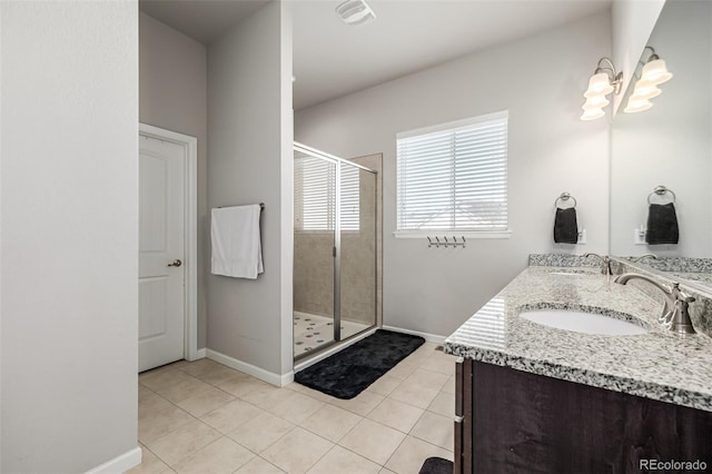 bathroom with tile patterned flooring, vanity, an inviting chandelier, and walk in shower