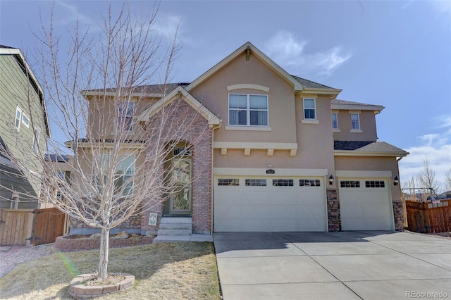 traditional home with stucco siding, an attached garage, driveway, and fence