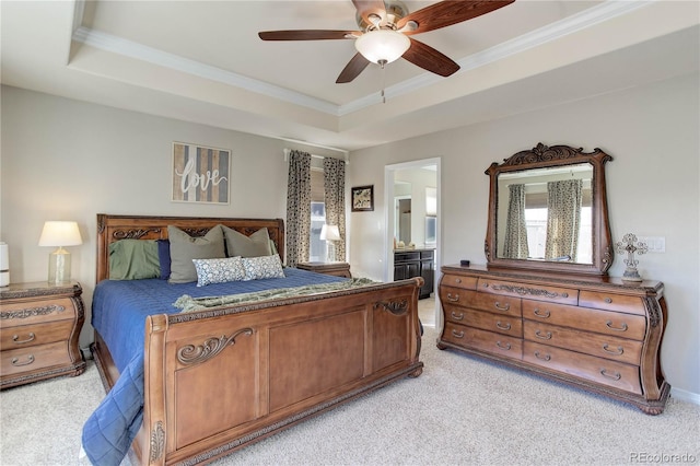 bedroom with connected bathroom, a raised ceiling, light colored carpet, and crown molding