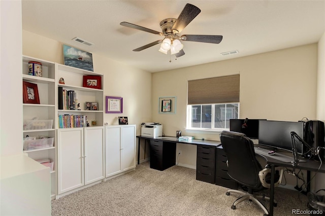 office with a ceiling fan, visible vents, and light carpet