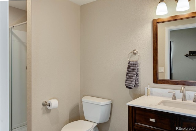 bathroom featuring vanity, toilet, and an enclosed shower