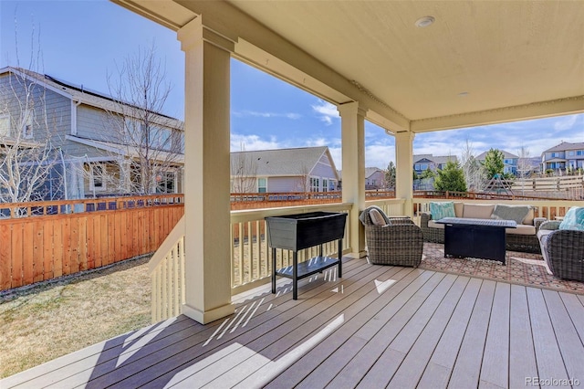 wooden deck with an outdoor living space, a residential view, and a fenced backyard