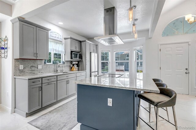 4013 S Carson St Unit C, Aurora, CO 80014 - kitchen with gray cabinetry, island exhaust hood, a sink, appliances with stainless steel finishes, and a breakfast bar