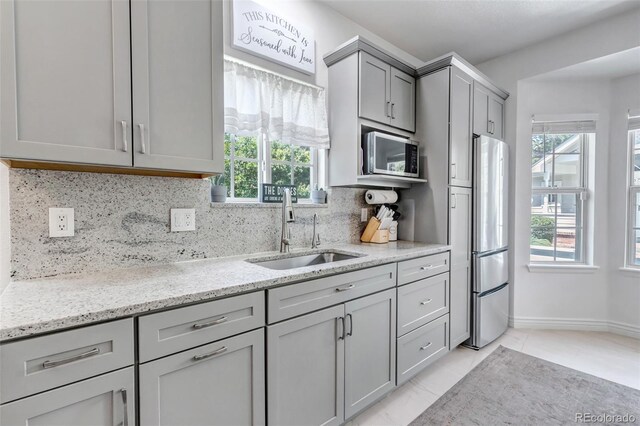 4013 S Carson St Unit C, Aurora, CO 80014 - kitchen featuring a sink, gray cabinets, appliances with stainless steel finishes, tasteful backsplash, and healthy amount of natural light