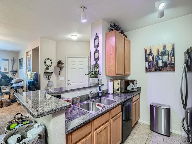 kitchen with kitchen peninsula, sink, dark stone countertops, black dishwasher, and fridge