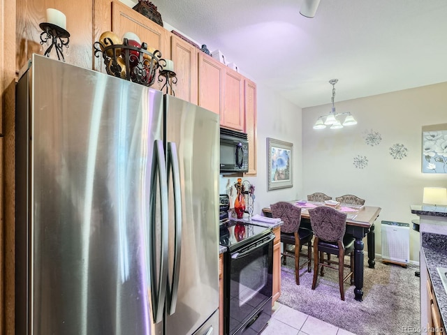 kitchen with black appliances, decorative light fixtures, light tile patterned floors, and a chandelier