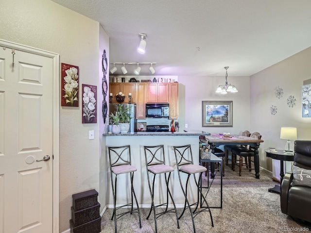 kitchen featuring a breakfast bar, light carpet, decorative light fixtures, a notable chandelier, and kitchen peninsula