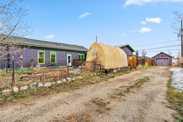 532 Front St, Fairplay, CO 80440 - back of property with dirt driveway, a garage, an outbuilding, and fence