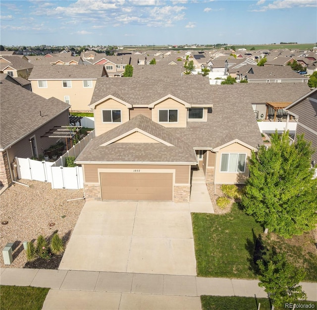 1057 Mt Oxford Ave, Severance, CO 80550 - view of front facade with a residential view, a shingled roof, concrete driveway, and stone siding