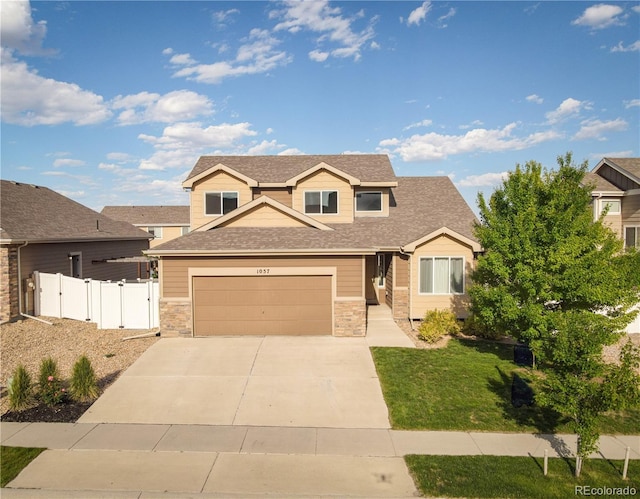 1057 Mt Oxford Ave, Severance, CO 80550 - view of front facade with driveway, a garage, stone siding, and roof with shingles