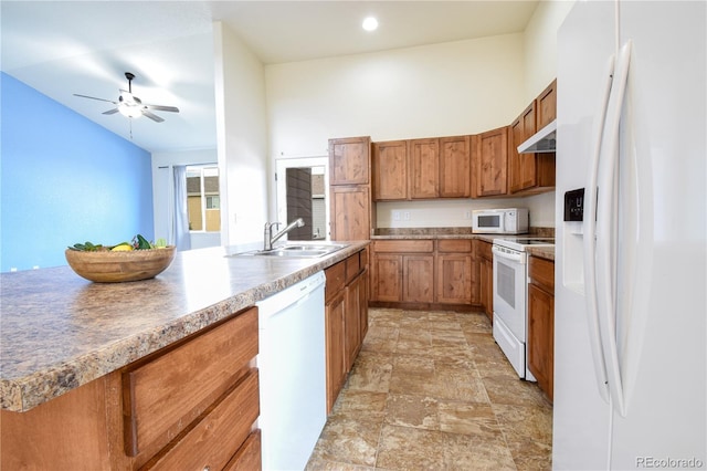 1057 Mt Oxford Ave, Severance, CO 80550 - kitchen with white appliances, brown cabinetry, ceiling fan, stone finish floors, and under cabinet range hood