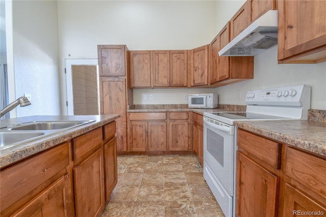 1057 Mt Oxford Ave, Severance, CO 80550 - kitchen featuring white appliances, under cabinet range hood, stone finish floors, and brown cabinetry