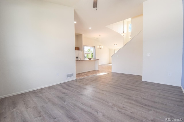 1057 Mt Oxford Ave, Severance, CO 80550 - unfurnished living room featuring a chandelier, wood finished floors, vaulted ceiling, recessed lighting, and a ceiling fan