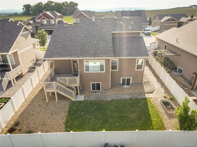 1057 Mt Oxford Ave, Severance, CO 80550 - rear view of house featuring a shingled roof, a fenced backyard, and a residential view
