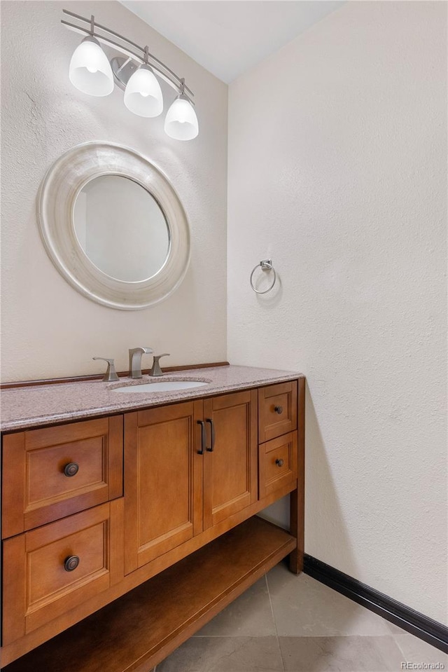 bathroom with tile patterned floors, baseboards, and vanity