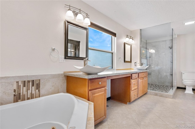 full bath with tile patterned floors, a jetted tub, a textured ceiling, a shower stall, and a sink