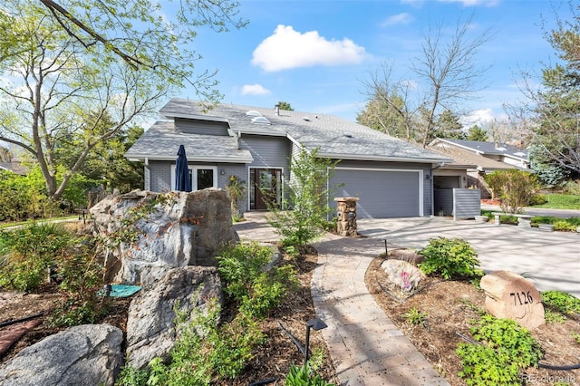 view of front of home with concrete driveway, brick siding, roof with shingles, and an attached garage