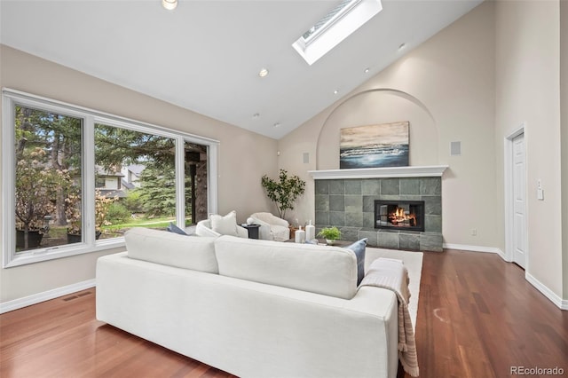 living room with wood finished floors, baseboards, visible vents, and a tile fireplace