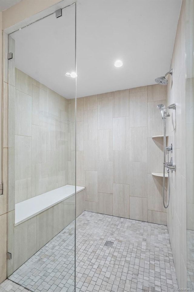 full bath with tile walls, tiled shower, and tile patterned floors