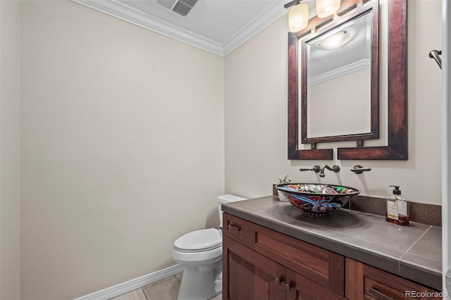 half bath featuring toilet, vanity, ornamental molding, visible vents, and baseboards