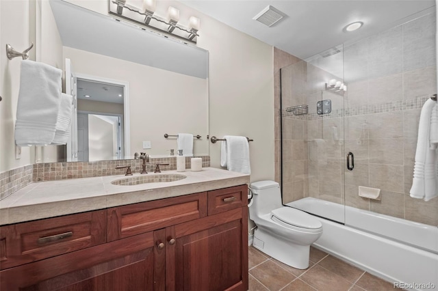 bathroom with toilet, enclosed tub / shower combo, tile patterned floors, visible vents, and vanity