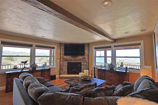 living area featuring beamed ceiling, wood finished floors, and baseboards