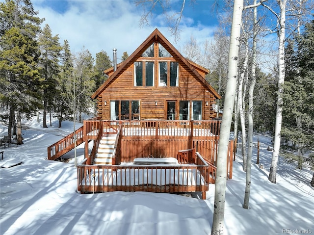 11498 Pauls Ln, Conifer, CO 80433 - snow covered back of property with a deck, stairway, and log exterior