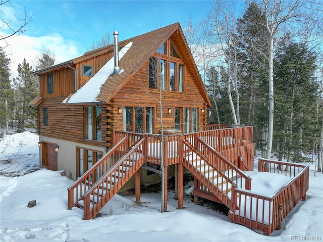 11498 Pauls Ln, Conifer, CO 80433 - snow covered house featuring log siding, stairway, a deck, and a garage