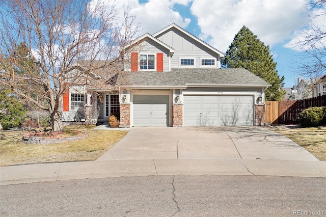 craftsman house featuring fence, board and batten siding, and concrete driveway