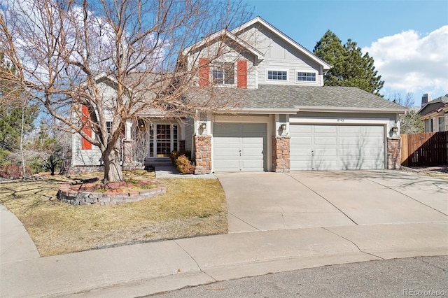 view of front of property with stone siding, fence, and driveway