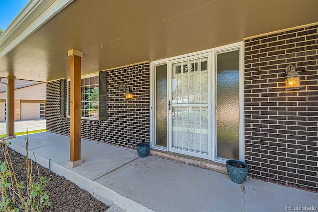 property entrance featuring covered porch and a garage