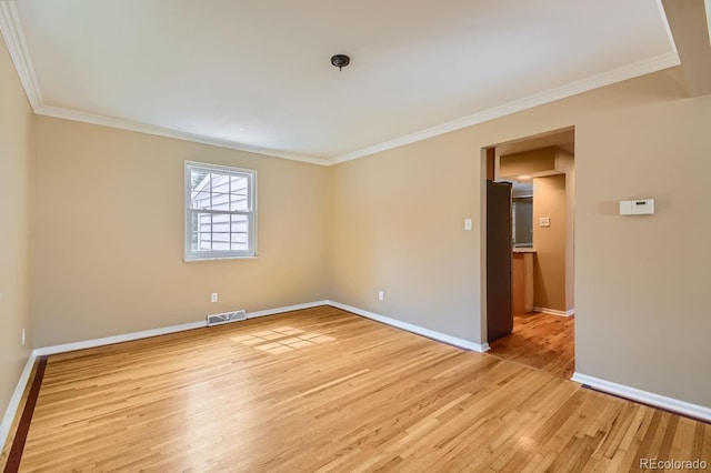 spare room with crown molding and light hardwood / wood-style flooring