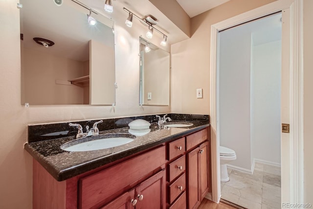 bathroom featuring dual vanity, toilet, and tile patterned floors