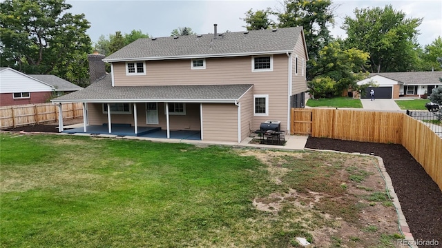 back of house featuring a patio and a lawn