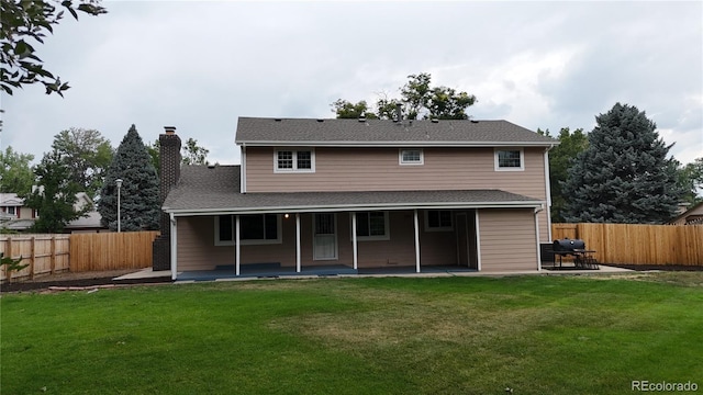 rear view of property with a patio and a lawn