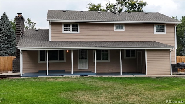 rear view of house featuring a patio area and a yard