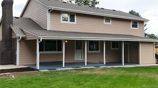 back of property with a patio and a yard