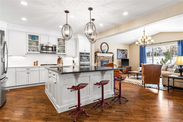 kitchen featuring white cabinetry, appliances with stainless steel finishes, a center island, and a kitchen breakfast bar