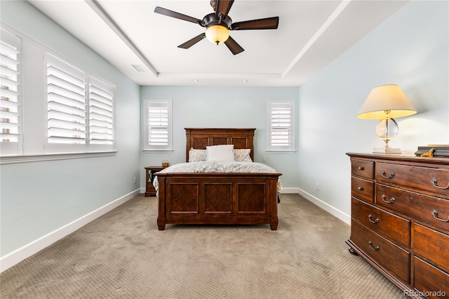 bedroom featuring multiple windows, light carpet, and ceiling fan