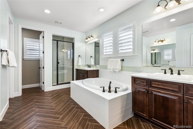 bathroom with vanity and shower with separate bathtub