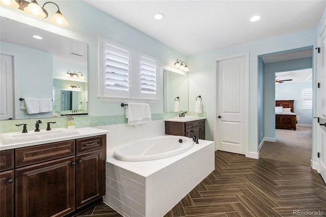 bathroom featuring vanity and tiled bath