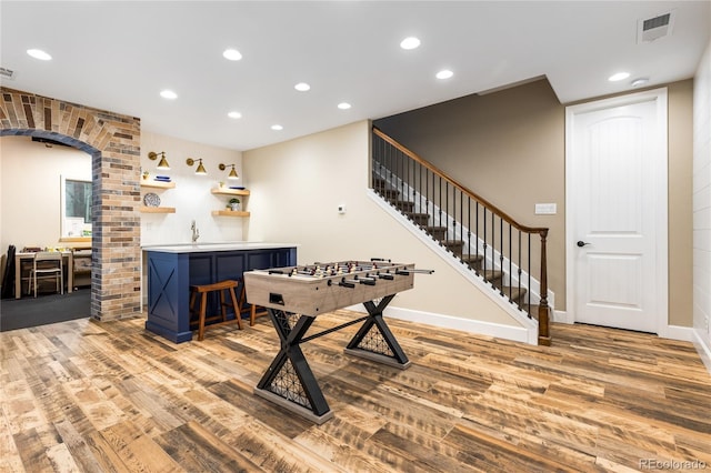 recreation room featuring bar area and light wood-type flooring