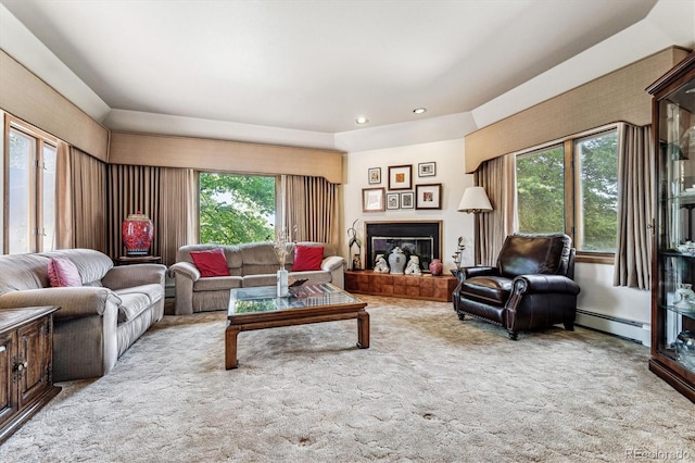 living room featuring baseboard heating, plenty of natural light, and light colored carpet