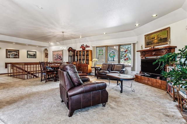 carpeted living room featuring an inviting chandelier