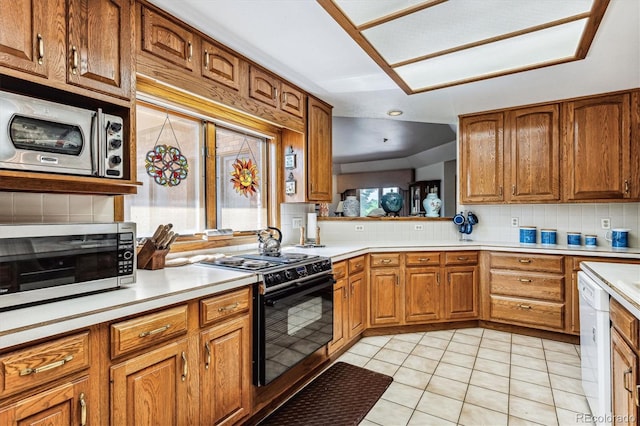 kitchen with stainless steel microwave, black stove, white dishwasher, decorative backsplash, and light tile patterned flooring