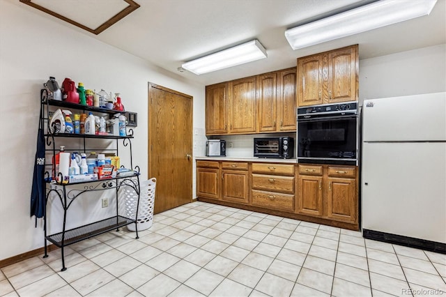 kitchen featuring black oven and white fridge