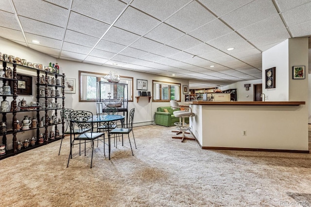 unfurnished dining area featuring carpet flooring and a drop ceiling